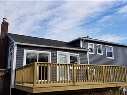 Completed dark blue vinyl siding with new deck.